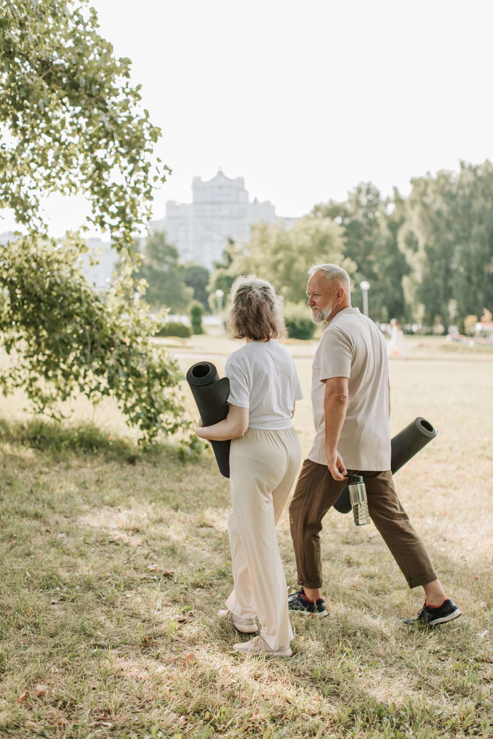 Two adults exercising together outdoors on a bright morning