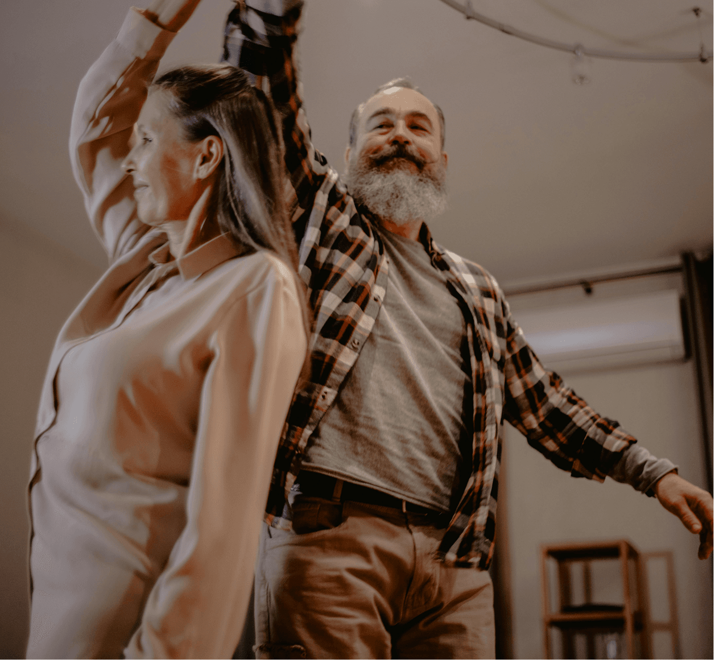 An older couple dancing together at home